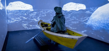 imagem de uma estátua azul remando dentro de um barco amarelo